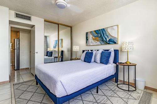 a bedroom with a large bed with blue pillows at Stylish Beach Condo ,1BR , City View Escape in San Juan