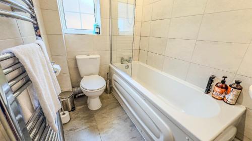 a bathroom with a toilet and a bath tub at 3BR House Near Cardiff Bay City Centre and Stadium with Free Parking in Cardiff