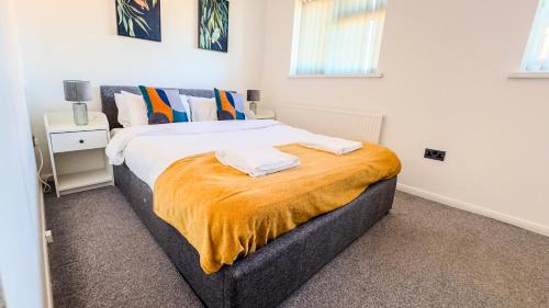 a bedroom with a bed with two towels on it at 3BR House Near Cardiff Bay City Centre and Stadium with Free Parking in Cardiff