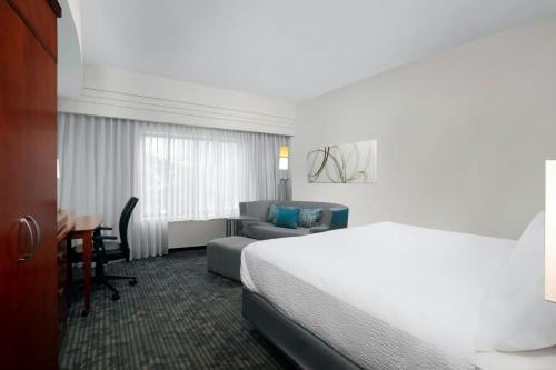 a hotel room with a bed and a couch at Courtyard by Marriott Jacksonville I-295/East Beltway in Jacksonville