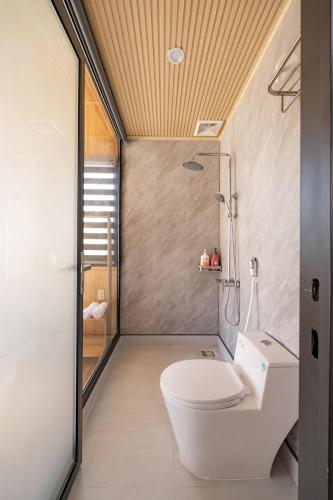 a bathroom with a toilet and a shower at Bin Home in Ấp Kim Thạch