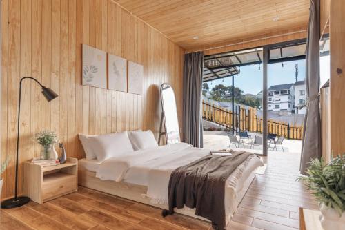 a bedroom with a bed and a balcony at Bin Home in Ấp Kim Thạch