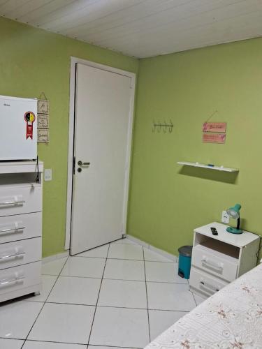 a room with a white door and a green wall at Pousadinha só in Foz do Iguaçu