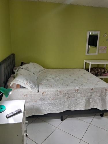 a bedroom with a large bed with a desk at Pousadinha só in Foz do Iguaçu