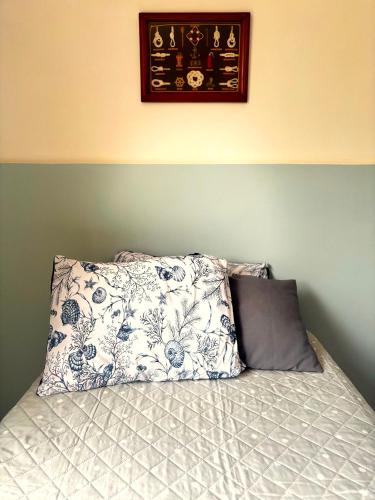 a bed with two pillows on top of it at Suíte aMAR in São Pedro da Aldeia