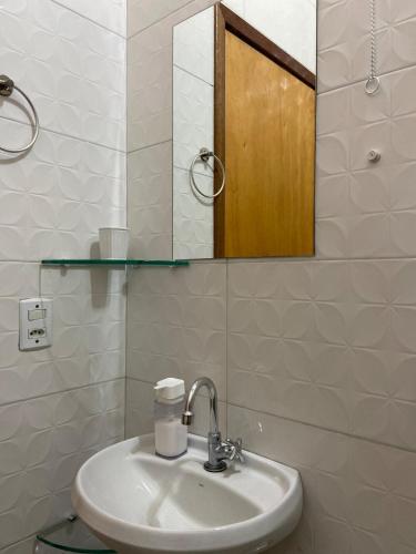 a bathroom with a sink and a mirror at Apto Aconchegante Próximo ao Centro! in Sinop
