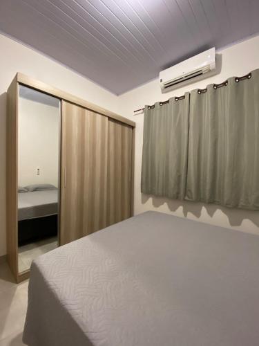 a bedroom with a bed and a air conditioner at Apto Aconchegante Próximo ao Centro! in Sinop