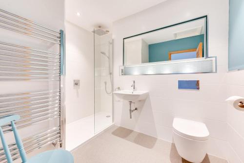 a white bathroom with a toilet and a sink at 2 Bed in Southwold oc-weh in Southwold