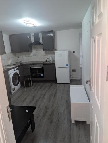 a small kitchen with a refrigerator and a microwave at The Apartment in Oldham
