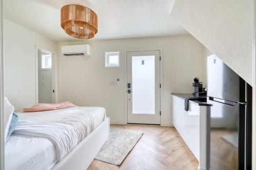 a white bedroom with a bed and a door at Stay Portland - Alberta Arts District Studio Suite in Portland