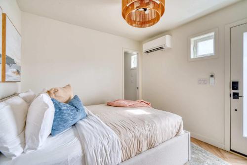 a bedroom with white walls and a bed with pillows at Stay Portland - Alberta Arts District Studio Suite in Portland
