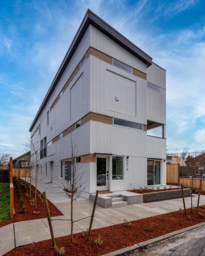 a white building with a black roof at Stay Portland - Alberta Arts District Studio Suite in Portland