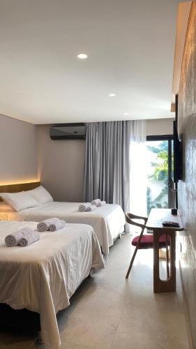 ein Hotelzimmer mit zwei Betten und einem Tisch in der Unterkunft Waves & Ko in San Andrés