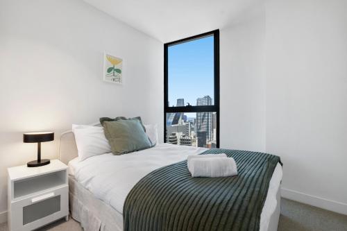 a bedroom with a bed and a large window at Skyline City Apartment with Pool & Gym & Sauna in Melbourne