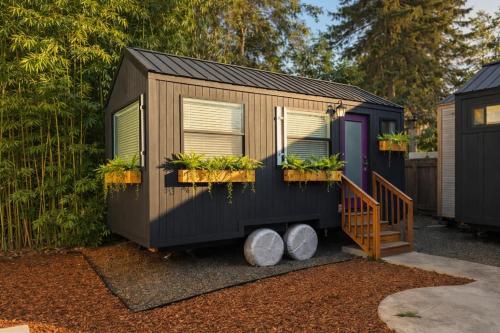a black tiny house with plants in a yard at Stay Portland - Mississippi Micro-Luxe - Mid-Century Style in Piedmont