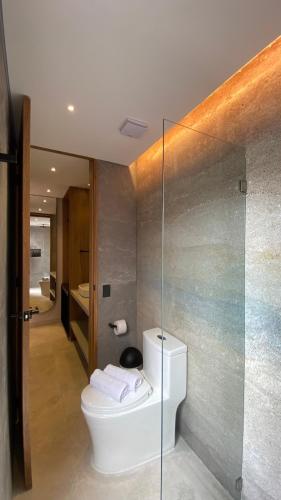 ein Badezimmer mit Toilette und Glaswand in der Unterkunft Waves & Ko in San Andrés