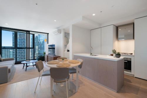 a kitchen and living room with a table and a counter at Skyline City Apartment with Pool & Gym & Sauna in Melbourne