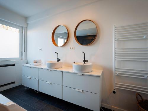two sinks in a bathroom with two mirrors at LOFT-54 -Exclusive Apartment with Terrace in Zwevegem
