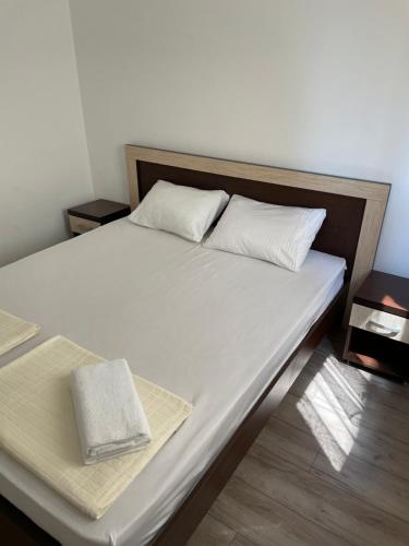 a large white bed with a wooden head board at Lupo in Budva