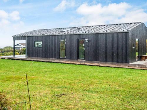 a black house with a black roof at 6 person holiday home in Rønde-By Traum in Rønde