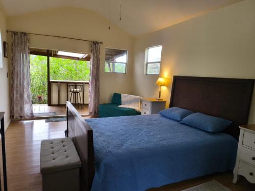 a bedroom with a bed with a blue bedspread at Bhoga Forest in Muñeco