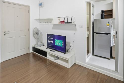 a living room with a tv on a white table at Spacious 1BR wSofa Bed Pool Gym 1Gbps Wi-Fi in Kathu