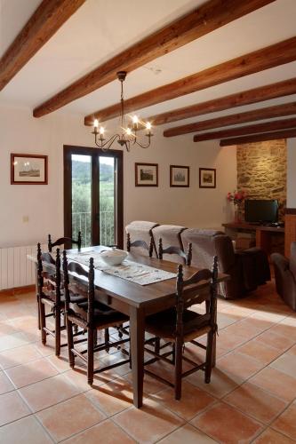a dining room with a wooden table and chairs at Vilars 10 in Espolla