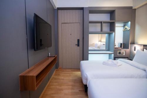 a hotel room with two beds and a television at ไดมอนด์ โฮเทล in Ban Krasang