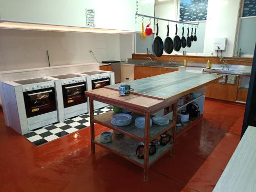 a kitchen with a table in the middle of it at The Duke Hostel in Greymouth