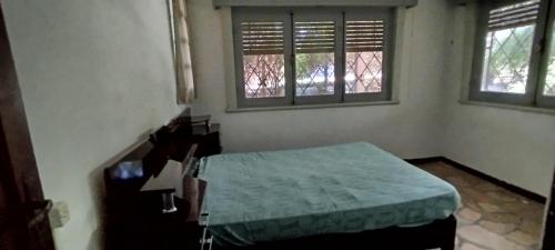 a bedroom with a bed and two windows at Chalet para desconectar in Piriápolis