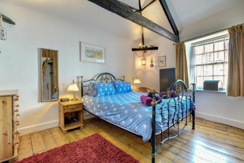 a bedroom with a blue bed and a mirror at 3 Bed in Torquay oc-h75059 in Torquay