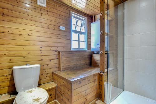 a wooden bathroom with a toilet and a shower at 3 Bed in Torquay oc-h75059 in Torquay