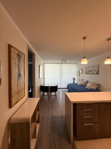 a bedroom with a bed and a table in a room at Depto a 2 pasos Mall Parque Arauco 301 in El Cerrillo