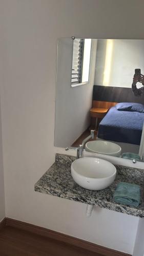 a bathroom with a counter with two sinks and a mirror at Paraiso da Mantiqueira - Staffy House Extrema in Extrema