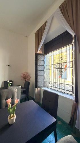 a dining room with a table and a window at Hotel y Hostal AH MUN in Mérida