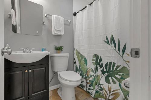 a bathroom with a toilet and a sink and a shower curtain at Modern Columbus 2BR Near COSI & Arena District in Columbus