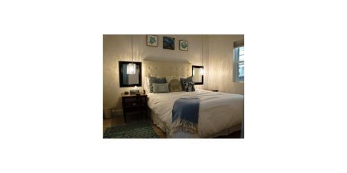 a bedroom with a white bed and a desk at Shared Space in SoSo Coastal Retreat in West Palm Beach