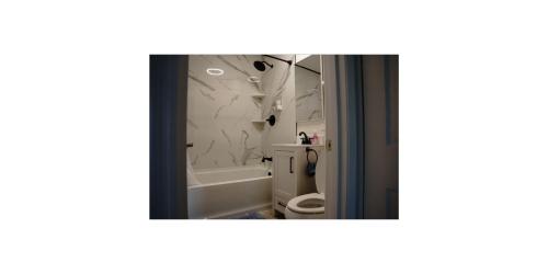 a bathroom with a tub and a toilet and a mirror at Shared Space in SoSo Coastal Retreat in West Palm Beach