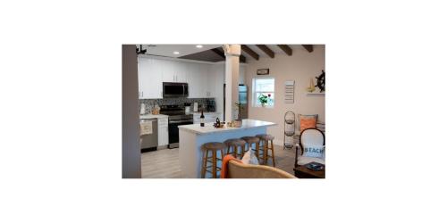 a kitchen and living room with a counter and chairs at Shared Space in SoSo Coastal Retreat in West Palm Beach