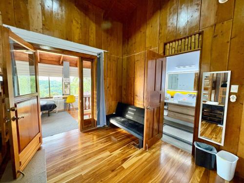 a living room with wooden walls and a wooden floor at Hotel Honey Bee in Alajuela