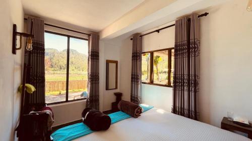 a bedroom with a bed and a large window at HAPUTHALE Ceylon shadow in Haputale