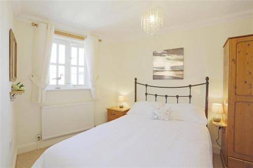 a bedroom with a white bed and a window at 3 Bed in Southwold oc-kit in Reydon
