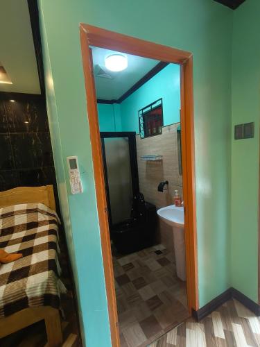 a bathroom with a door leading to a tub and a sink at Little Apple Inn in San Juan