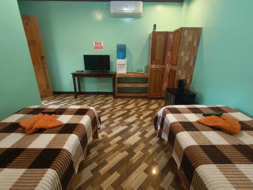 a hotel room with two beds and a tv at Little Apple Inn in San Juan