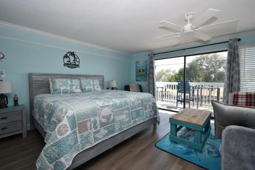 a bedroom with a bed and a sliding glass door at Cedar Key Islands Dolphins Cay Condo in Cedar Key