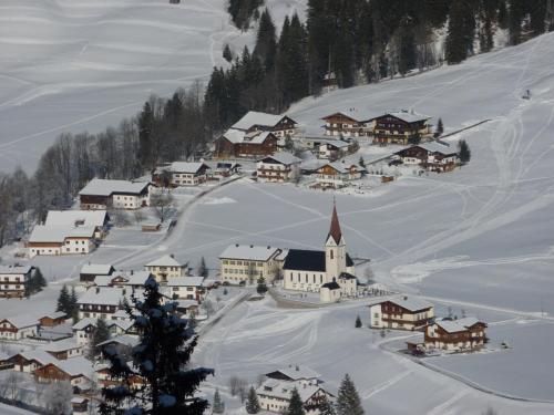 a small village covered in snow with a church at Auf der Sonnenseite in Schattwald