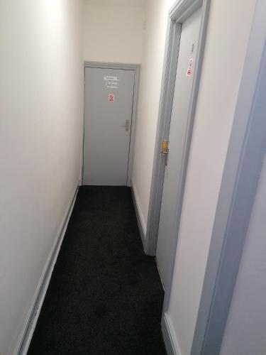 an empty hallway with a white door and a room at Regent Cosy Homes in Stoke on Trent