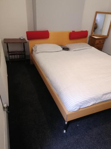 a bedroom with a large bed with a red headboard at Regent Cosy Homes in Stoke on Trent
