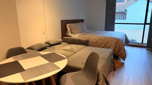 a living room with a couch and a bed and a table at Teusaquillo Urban Loft in Bogotá