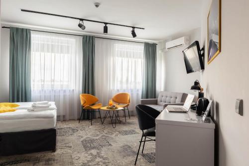a hotel room with a bed and a couch and a table at Hotel Nafta Krosno in Krosno